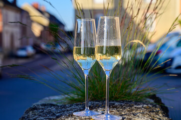 Tasting of premier cru sparkling white wine with bubbles champagne with view on old houses of...