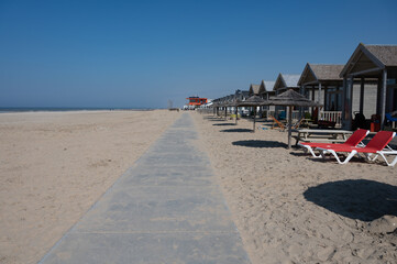 Beach holidays on sandy beach, waterfront wooden cottages in Katwijk-on-zee, North sea, Netherlands