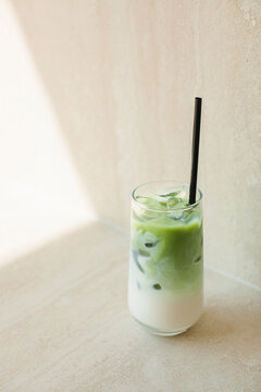Close-up of a matcha latte on a table in sunlight