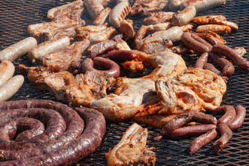 large mixed barbeque outdoors various meat cuts pork, beef, chicken, lamb and sausages