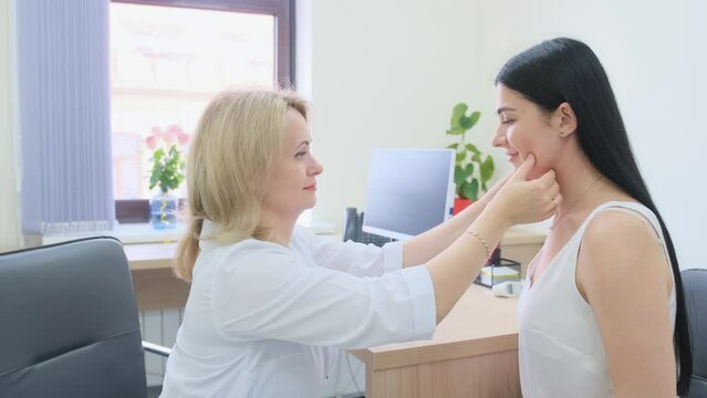 a female doctor examines the patient's throat in the office.