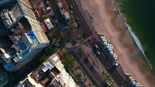 Aerial Top Forward View Of Vehicles On Street By Buildings And Sea During Sunrise - Rio de Janeiro, Brazil