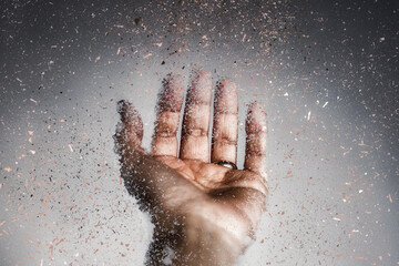 Close-up of an outstretched hand disintegrating