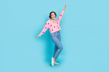 Fototapeta na wymiar Full body portrait of cheerful overjoyed lady raise arm have good mood dancing isolated on blue color background