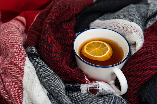 Close-up of a cup of hot black tea with lemon wrapped in a scarf