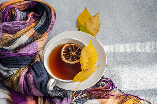 Overhead view of a cup of spiced black tea with lemon and autumnal styling
