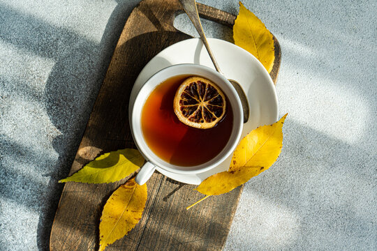 Overhead view of a cup of spiced black tea with lemon and autumnal styling