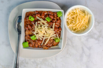 chili top with shredded cheese and scallions