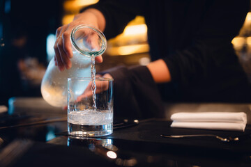 Kellnerin serviert Wasser im Restaurant