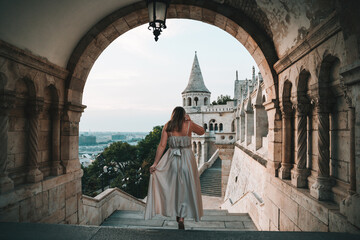Young Woman walking down the stairs in a dress in Budapest at the Fisherman's Bastion,...