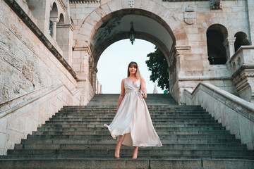 Young Woman walking down the stairs in a dress in Budapest at the Fisherman's Bastion, Halászbástya