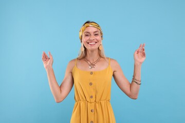 Portrait of smiling hippie woman on light blue background