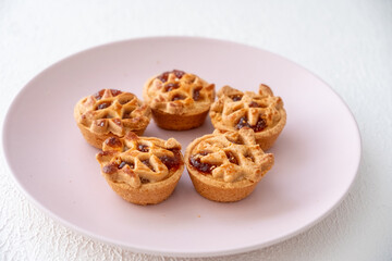 Apple pie on a pink plate on a white background