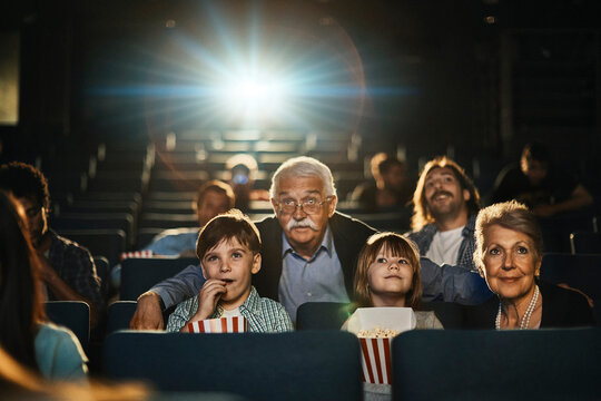 Multi-generational family engrossed in a captivating movie at the theater
