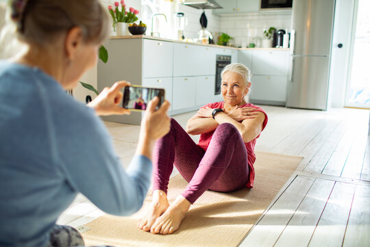 Daughter captures a proud moment of her senior mother practicing yoga at home