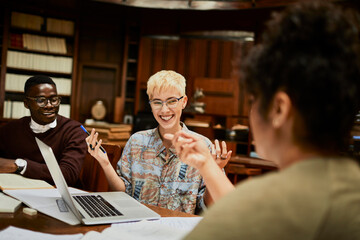 Enthusiastic students sharing a lighthearted moment during a study session at the university library