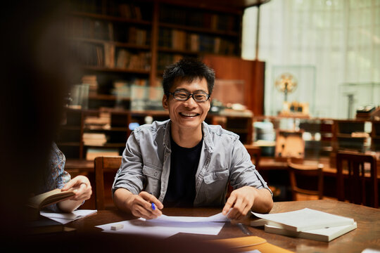 University student laughing during a group study in the library