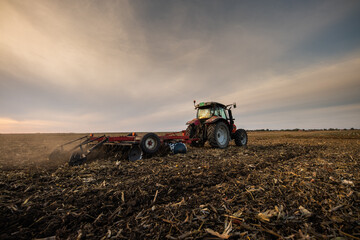 Fototapeta premium Farmer preparing his field in a tractor