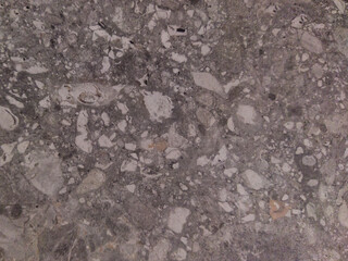 Old gray surface with dots. Gray background with a pattern. Concrete floor with stones.