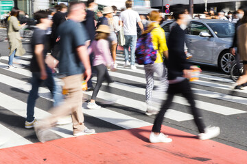 Naklejka premium crowds of people crossing a city street in Tokyo, Japan