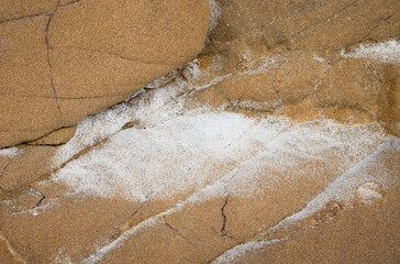 Sea salt dried on orange, cracked sandstone 