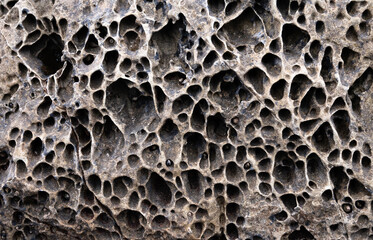 Textured gray rock structure with holes