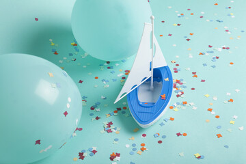 a sailboat navigating a sea of confetti among iceberg balloons.