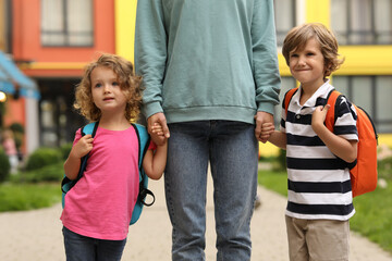 Woman and her children on their way to kindergarten outdoors