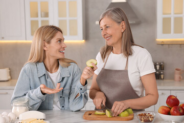 Happy mature mother and her daughter in kitchen