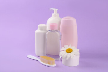 Different skin care products for baby and flower on violet background