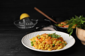 Tasty rice with shrimps and vegetables on dark wooden table. Space for text