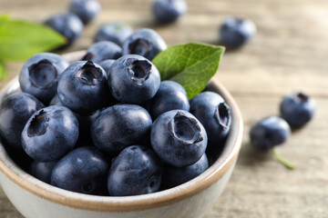 Bowl of fresh tasty blueberries on table, closeup. Space for text
