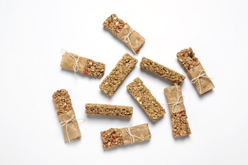 Tasty granola bars on white background, flat lay