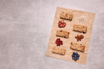 Different tasty granola bars and ingredients on light grey background, flat lay. Space for text