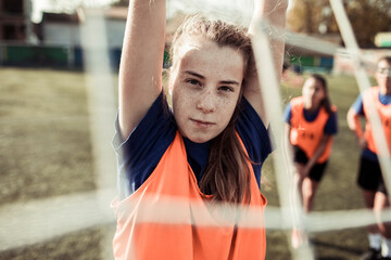 Portrait of a young female soccer player on a grass pitch