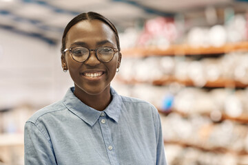 Young African woman smiling while standing in her warehouse