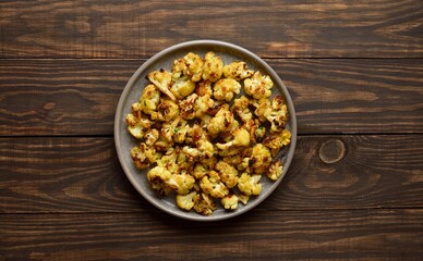 Roasted cauliflower on wooden background
