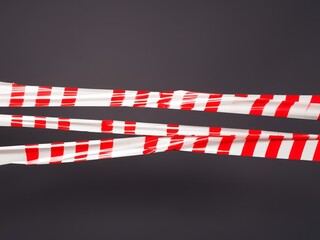 red white barrier tape in front of dark background