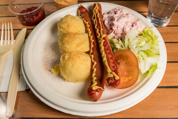 Two hot dogs served with mashed potatoes and shrimp salad.