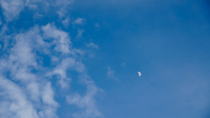 Half moon on a blue sky day.