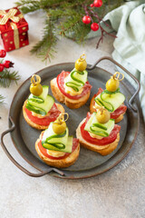 Creative appetizers christmas. Christmas tree canapes of salami, cheese, olives, tomatoes and cucumbers on a baguette. Copy space.