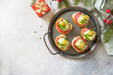 Creative appetizers christmas. Christmas tree canapes of salami, cheese, olives, tomatoes and cucumbers on a baguette. View from above. Copy space.