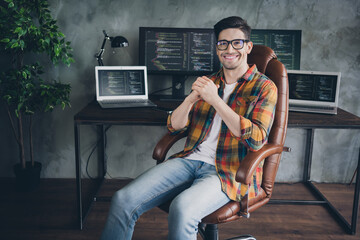 Portrait of cheerful skilled cyber security expert sit chair desk pc netbook display loft interior...