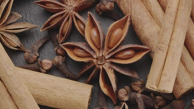 Lots of three spices for mulled wine &ndash; star anise, cinnamon and clove slowly scroll clockwise, macro video footage. A great background for your projects.