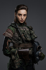 Portrait of a woman in military attire, portraying a rebel or partisan, against a gray background, depicting a Middle Eastern conflict