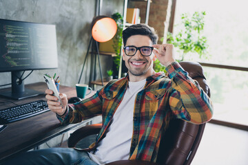 Portrait of cheerful businessman geek enjoying touching new anti glare coating eyeglasses sit...