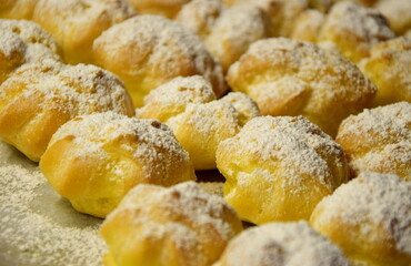 Süße Profiteroles, Windbeutel mit Zucker und Vanillecreme, Leckerei und Süßspeise, Nachspeise als Dessert, Hintergrund 