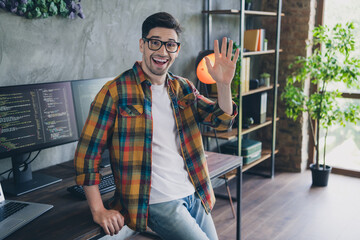 Photo of excited positive project manager sit desktop arm waving hi loft interior business center inside © deagreez