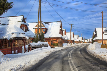 Winter road in polish village valley with old wooden houses. Tatra Mountains