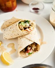 Beef and Lamb Lebanese style shawarma with onions, greens and vegetables such cucumber and tomato. all seasoned with tahini and garlic sauce and wrapped in pita or pita bread.